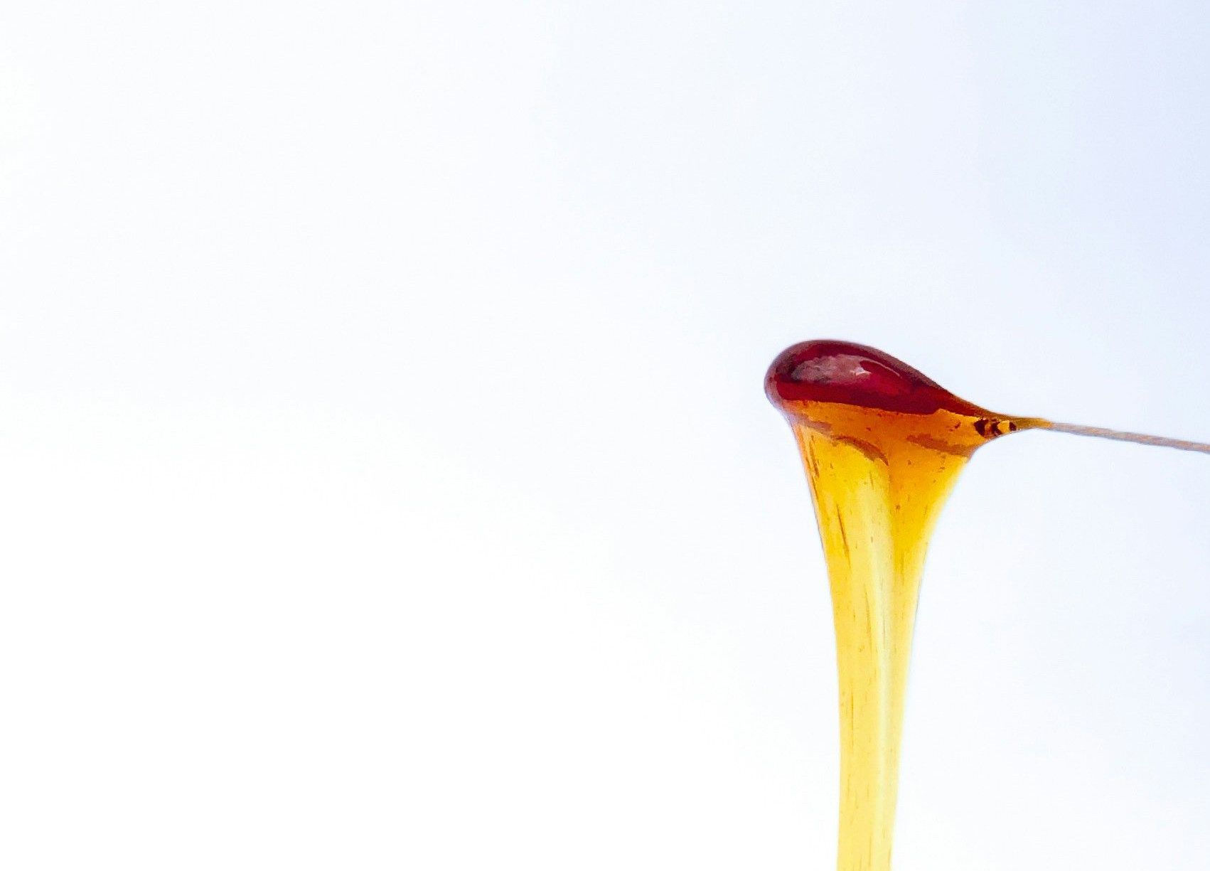 a jar of sugar wax with a spoon sticking out of it